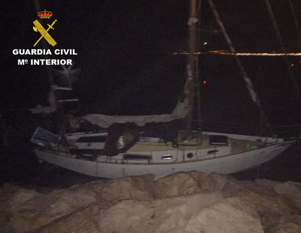 La Guardia Civil auxilia a dos personas y su perro en un velero encallado en las rocas en Almerimar