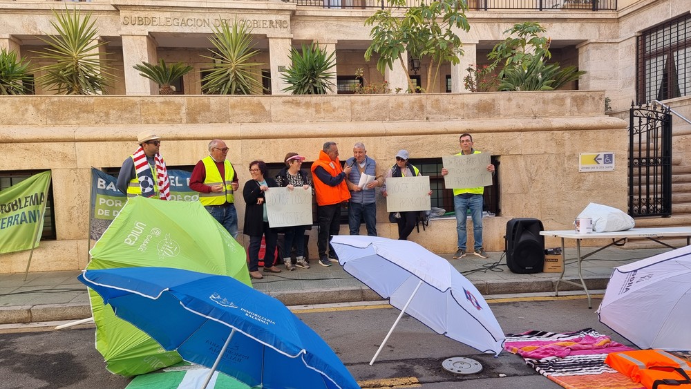 Balerma lleva sus sombrillas y toallas como reivindicación ante la puerta de la Subdelegación de Gobierno
